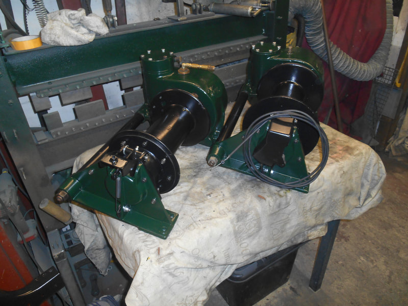 2 Land Rover Hydraulic winches after having been painted in green and black.