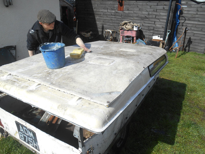 Scrubbing the top of a Land Rover Series 2a Safari Roof to remove Lichen and dirt.