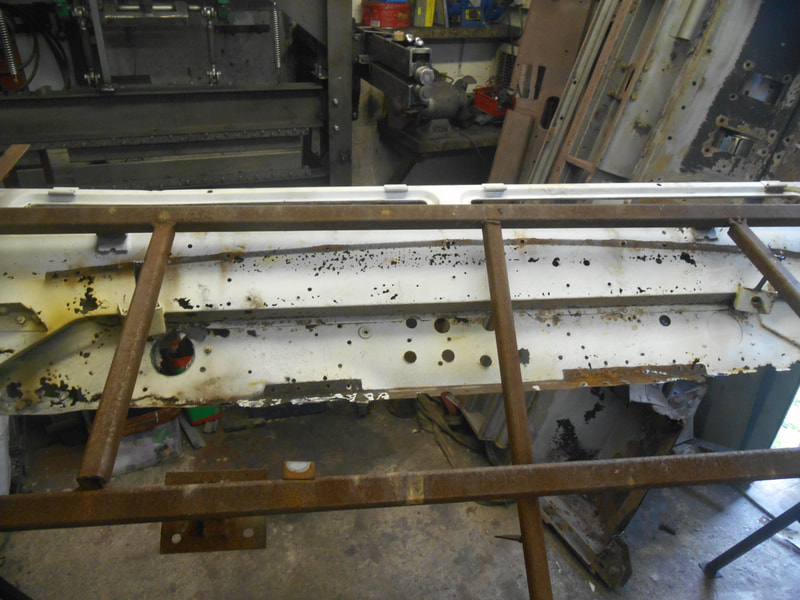 Centre top half of a rusty bulkhead before restoration in a jig.
