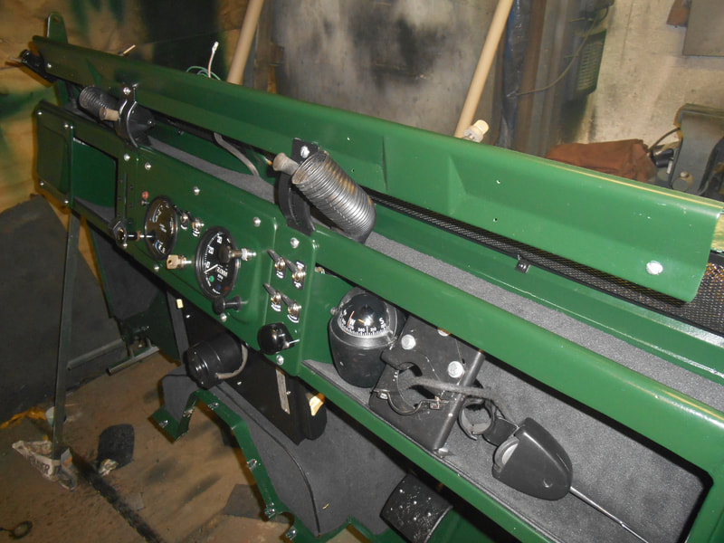 Land Rover Series 2a bulkhead painted in dark green with components fitted viewed from inside.