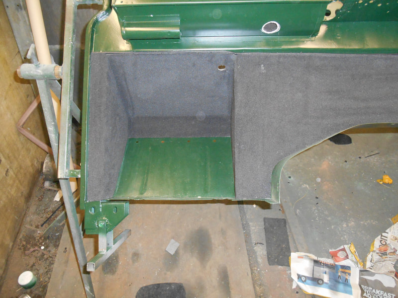 Land Rover Series 2a bulkhead painted in dark green showing black carpet fitted to passenger foot well.