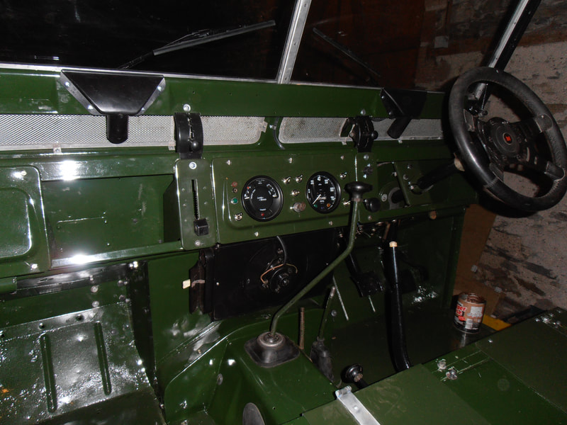 Passenger view of green Land Rover Series 2a bulkhead with dash and steering wheel fitted.